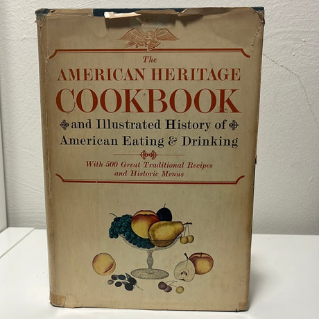 The American Heritage Cookbook and Illustrated History of American Eating & Drinking on a table, featuring recipes and historical insights into American culinary heritage.