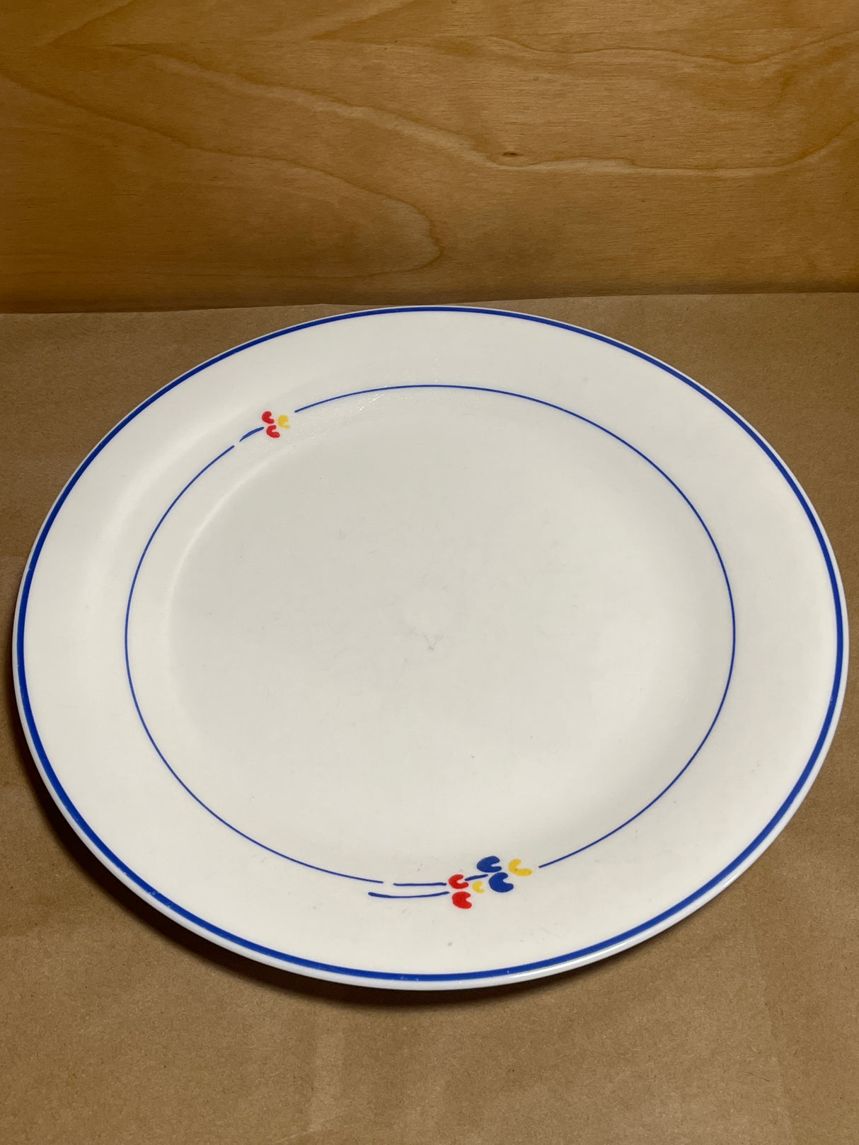 Rival Designs Tulip dinnerware collection Lot 3078: A white ceramic plate with blue bands and colorful floral accents, showcasing an elegant, minimalist design.