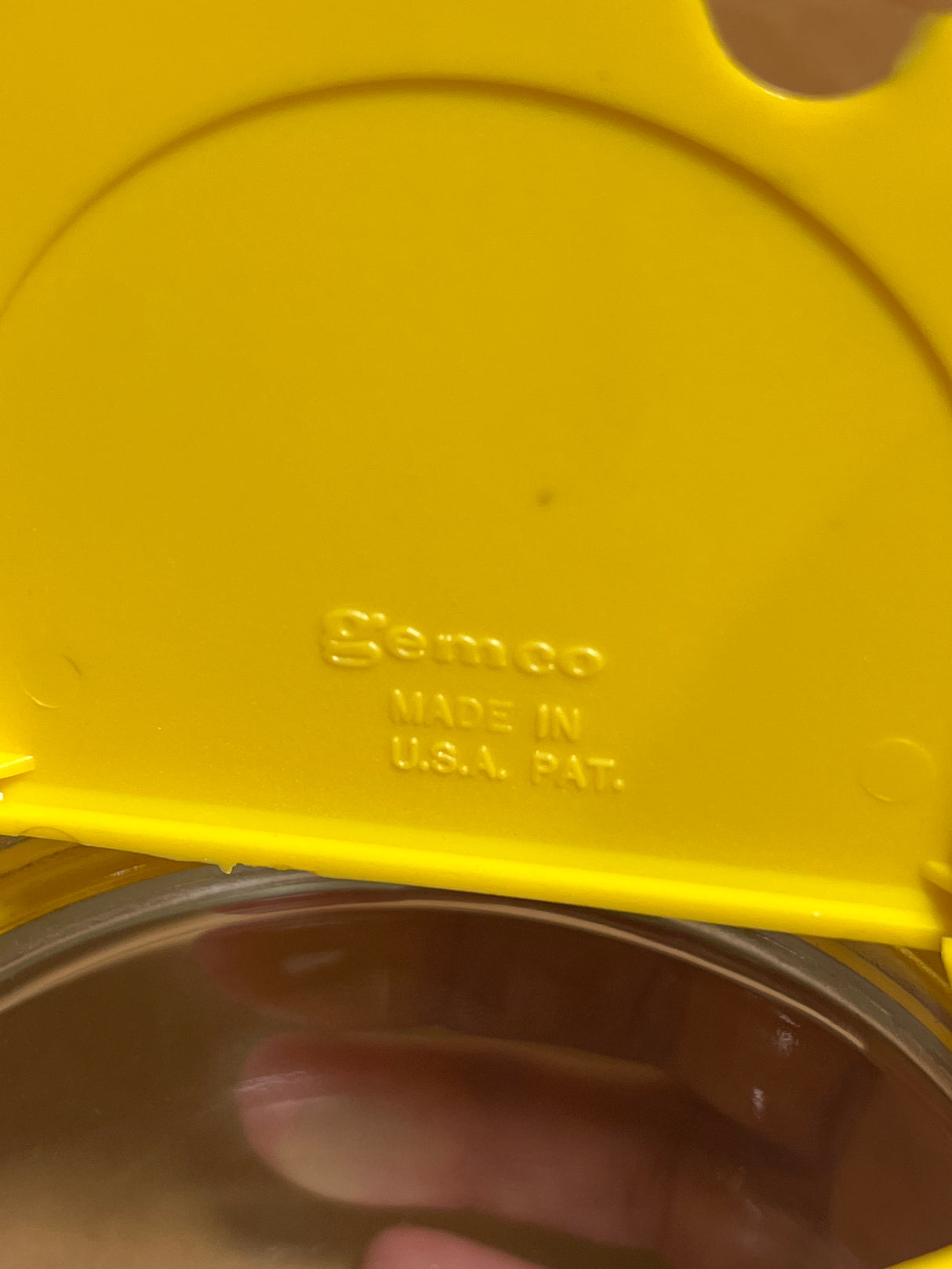 Close-up of a yellow lid embossed with Semco on a Gemco sugar and cream dispenser, showcasing its classic design and U.S. craftsmanship.
