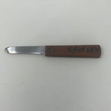 Stainless steel Japanese oyster shucking knife with wood handle, featuring initials of previous owner. Close-up of knife on wooden block.