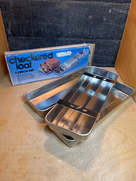 Battenburg cake divider checkered loaf 4-piece set with two loaf pans and inserts for creating a checkerboard pattern in cakes. Includes original box art.