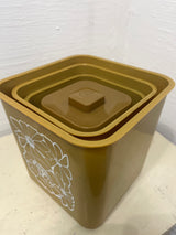 Melmac set of 4 retro food storage containers with mustard color and white floral illustrations, featuring a nesting design; one container has a small crack.