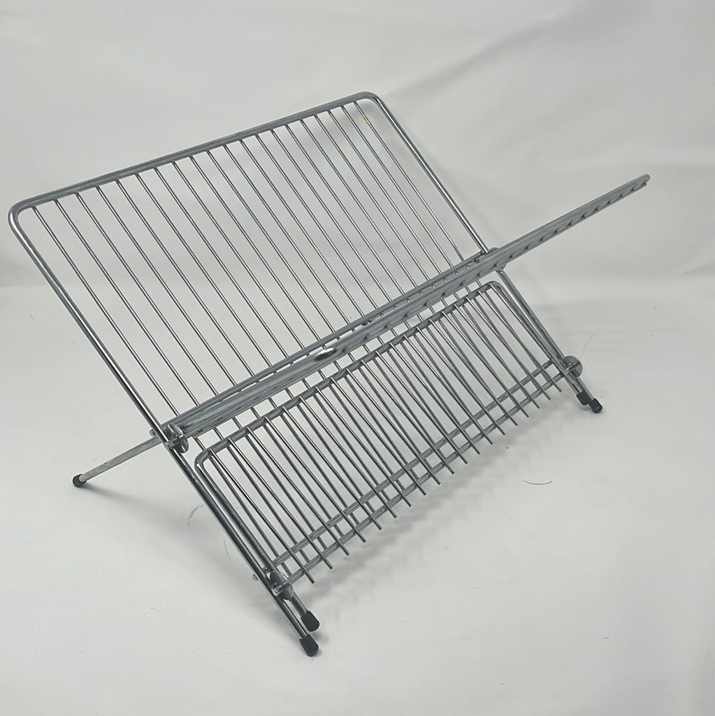 Foldable stainless steel wire dish drying rack with handle and rubber pads, close-up of metal rack on white background. From Spoons Kitchen Exchange.