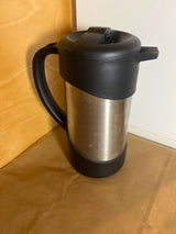 Thermos Nissan stainless steel insulated French press coffee maker with a black handle and lid, designed to keep beverages hot or cold efficiently.