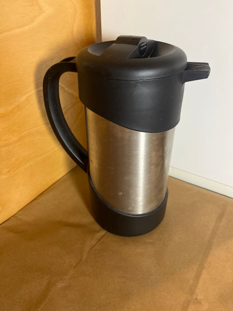 Thermos Nissan stainless steel insulated French press coffee maker with a black handle and lid, designed to keep beverages hot or cold efficiently.