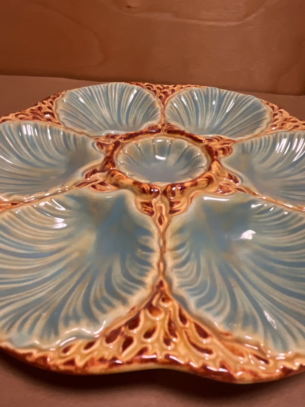 RARE French majolica oyster plate with six shell-shaped wells and a central sauce well, showcasing intricate detailing and a warm glaze, embodying antique French craftsmanship.