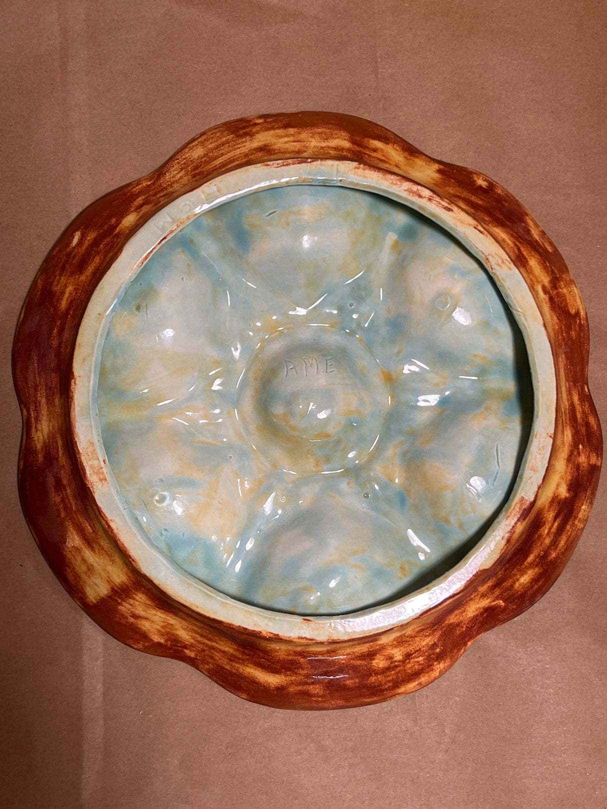RARE French majolica oyster plate with scalloped wells, rusty brown glaze, and aqua-cream interior. Features central well, intricate detailing, and a small chip.