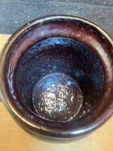 Vintage two-toned ceramic pot with lid, showing its glossy interior with white deposits, ideal for storing pantry goods on a kitchen countertop.