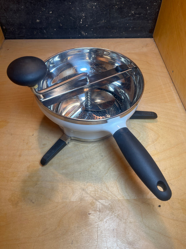 Stainless Steel Food Mill For Purees, Silver and White - OXO Good Grips, with a crank, grip handle, and folding support legs for stability and easy storage.