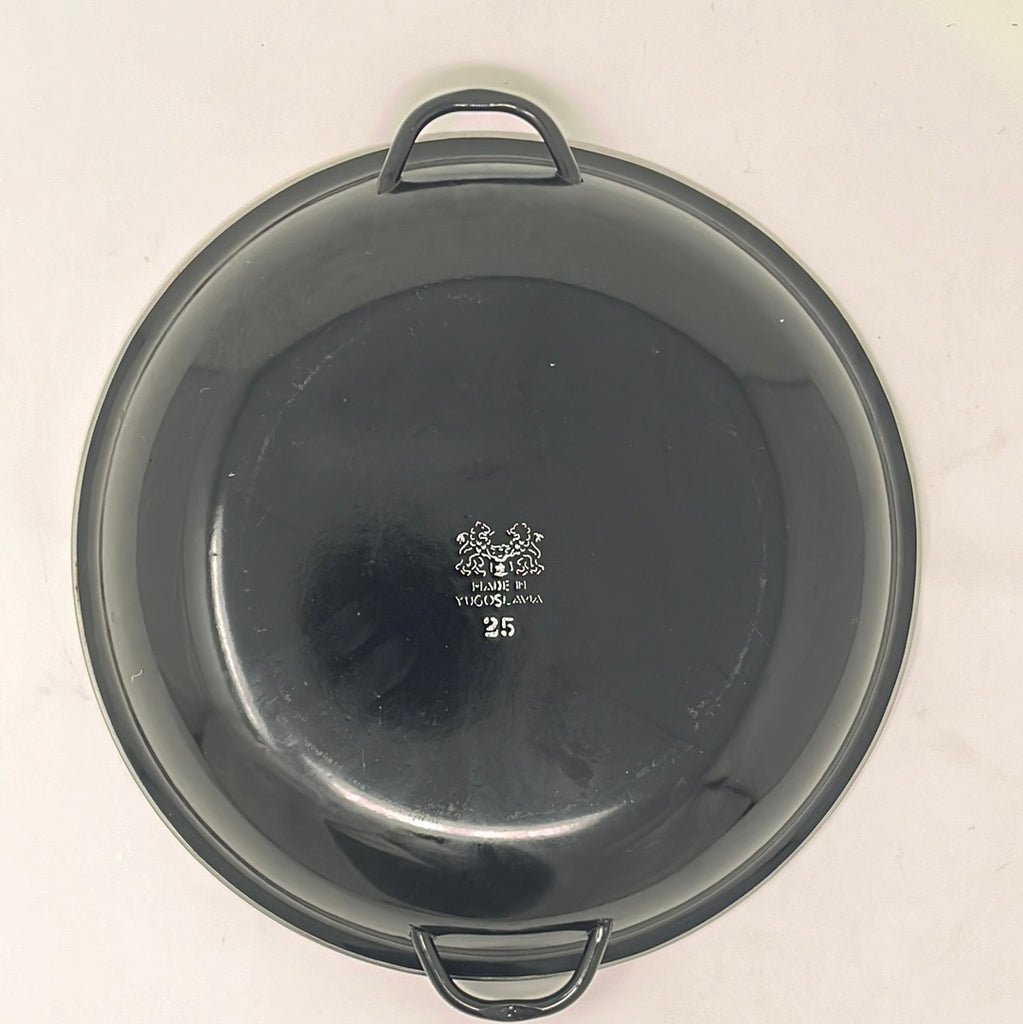 Vintage Paella Pan with handles, underside view. Black enamel stamped with white letters that say: "Made in Yugoslavia, 25." From Spoons Kitchen Exchange.