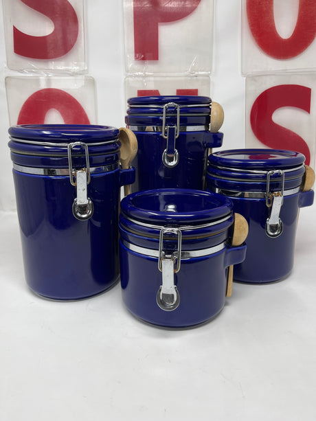 Blue ceramic food storage containers with metal handles and snap lids, each featuring a wooden scoop, designed for keeping dry goods fresh.