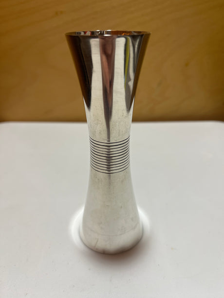 Towle sterling silver jigger shot glass featuring a sleek midcentury design with small dents on the edges, adding character to this elegant bar accessory.