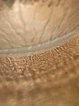 Viking 2408 cabbage 12 glass serving bowl with frosted, embossed cabbage design, casting wave-like light reflections on a wooden table. Perfect for salads.