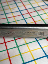 Close-up of metal piece from Large 16” restaurant serving tongs, Vollrath 4791620, with “274 X2VS,” “SHEBOYGAN WI USA,” and JP logo, on a grid mat.