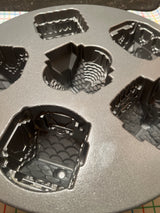 Cozy Village cast aluminum baking pan mold by Nordicware, featuring six decorative cavities for intricate mini-cakes, with nonstick surface ensuring easy release and uniform baking.