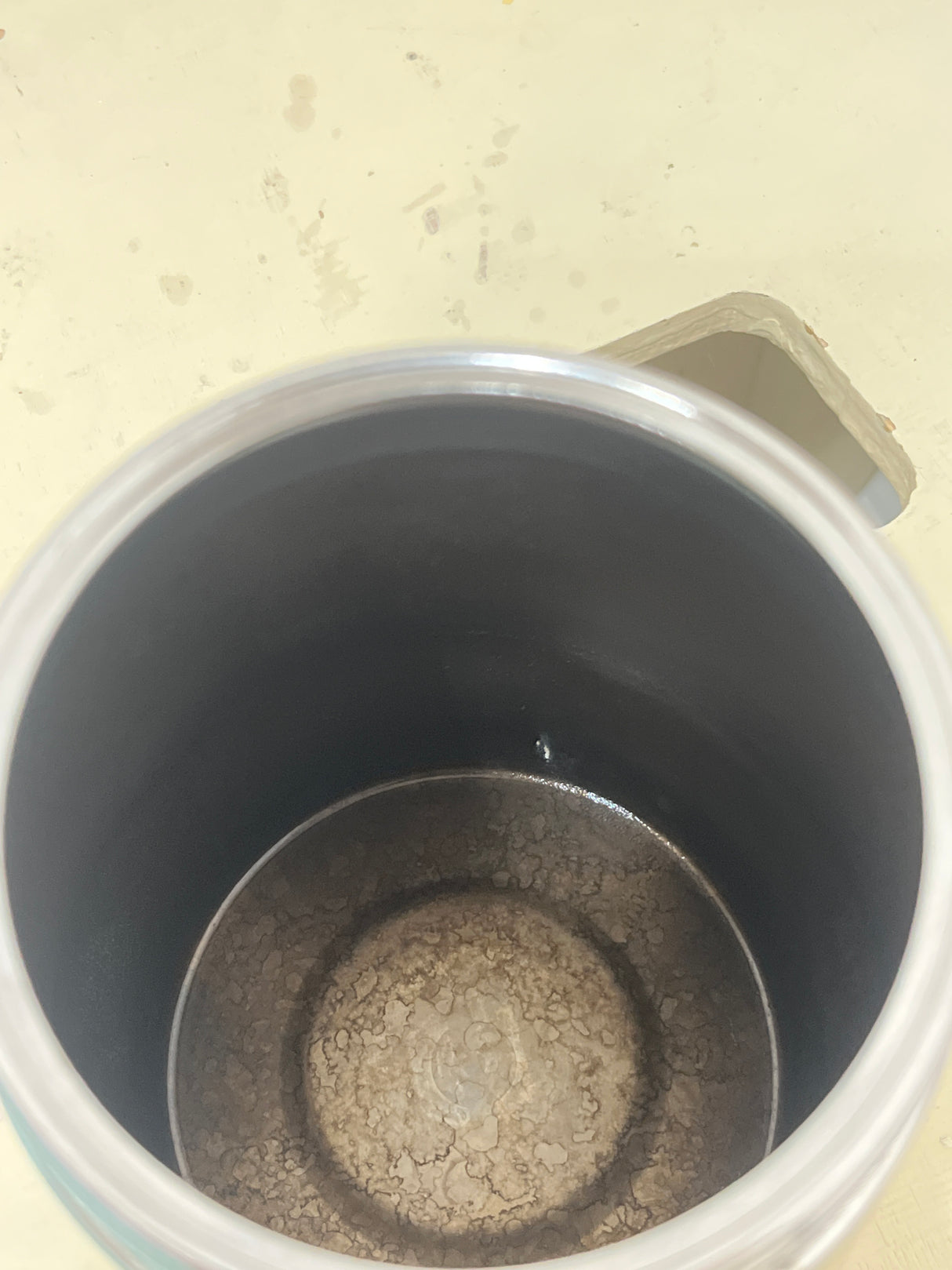 Ilsa Turbo Express 6-Cup 18/10 stainless steel stovetop espresso pot with visible limescale deposits inside, resting on a pale yellow surface.