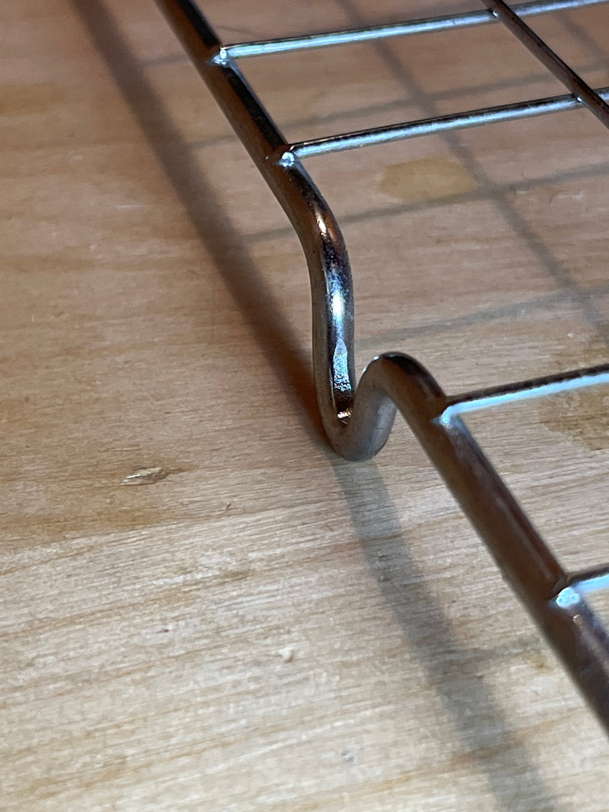 Wire cooling rack - 20 x 14.5 stainless steel with chrome plating, showing an S-shaped support leg and cross-wire grid on a wooden surface.