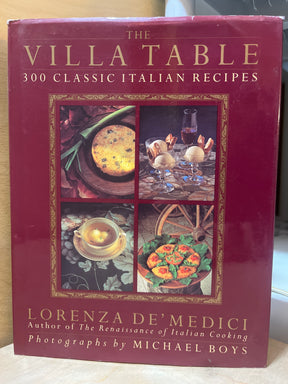 Cover of “The Villa Table” cookbook featuring four framed food photos, authored by Lorenza de’ Medici, highlighting 300 classic Italian recipes with photos by Michael Boys.