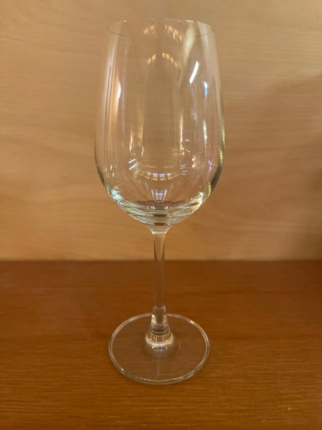 White wine stemmed glass with a modern flared bowl on a wooden surface, designed for optimal aeration and minimal heat transfer through its slender stem.
