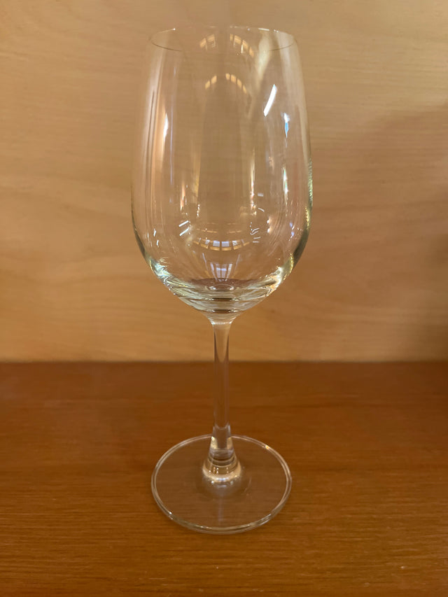 White wine stemmed glass with a modern flared bowl on a wooden surface, designed for optimal aeration and minimal heat transfer through its slender stem.
