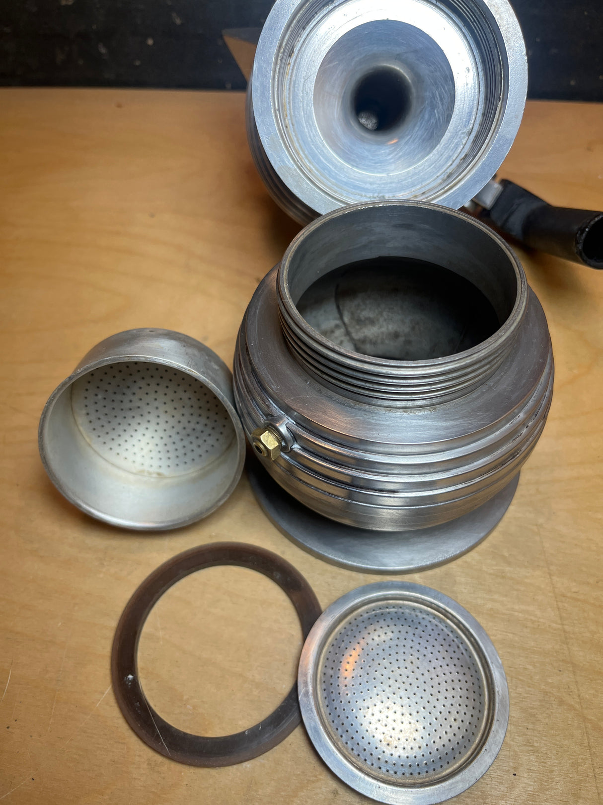 Disassembled RARE Alessi Pulcina 6-cup moka pot, showcasing components: bottom water chamber, upper collection chamber, coffee filter basket, perforated filter plate, and rubber gasket.