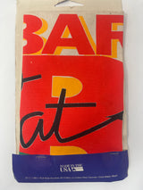 A close-up of a red and yellow fabric apron with black text, featuring the title Let's Eat! Gourmet Bar-B-Que. Original packaging, never worn.