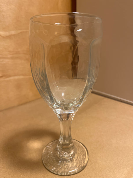 Libbey Chivalry glassware: a clear, stem-mounted goblet, elegantly empty, displayed against a wood-tone background. Ideal for wine or other beverages.