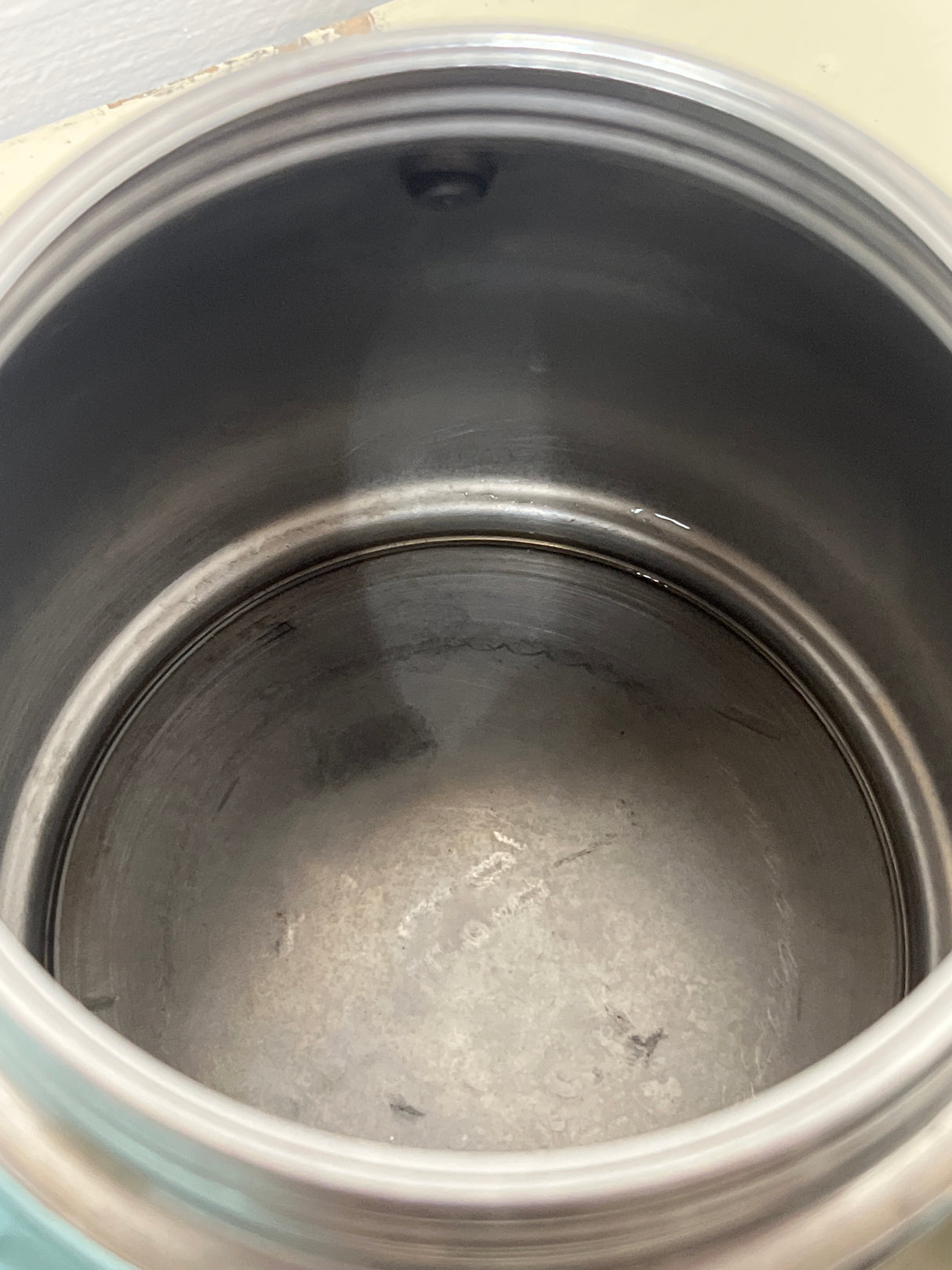 Interior view of a VEV Vigano Carioca 6-cup stainless steel stovetop espresso pot, showing minimal water residue at the bottom.