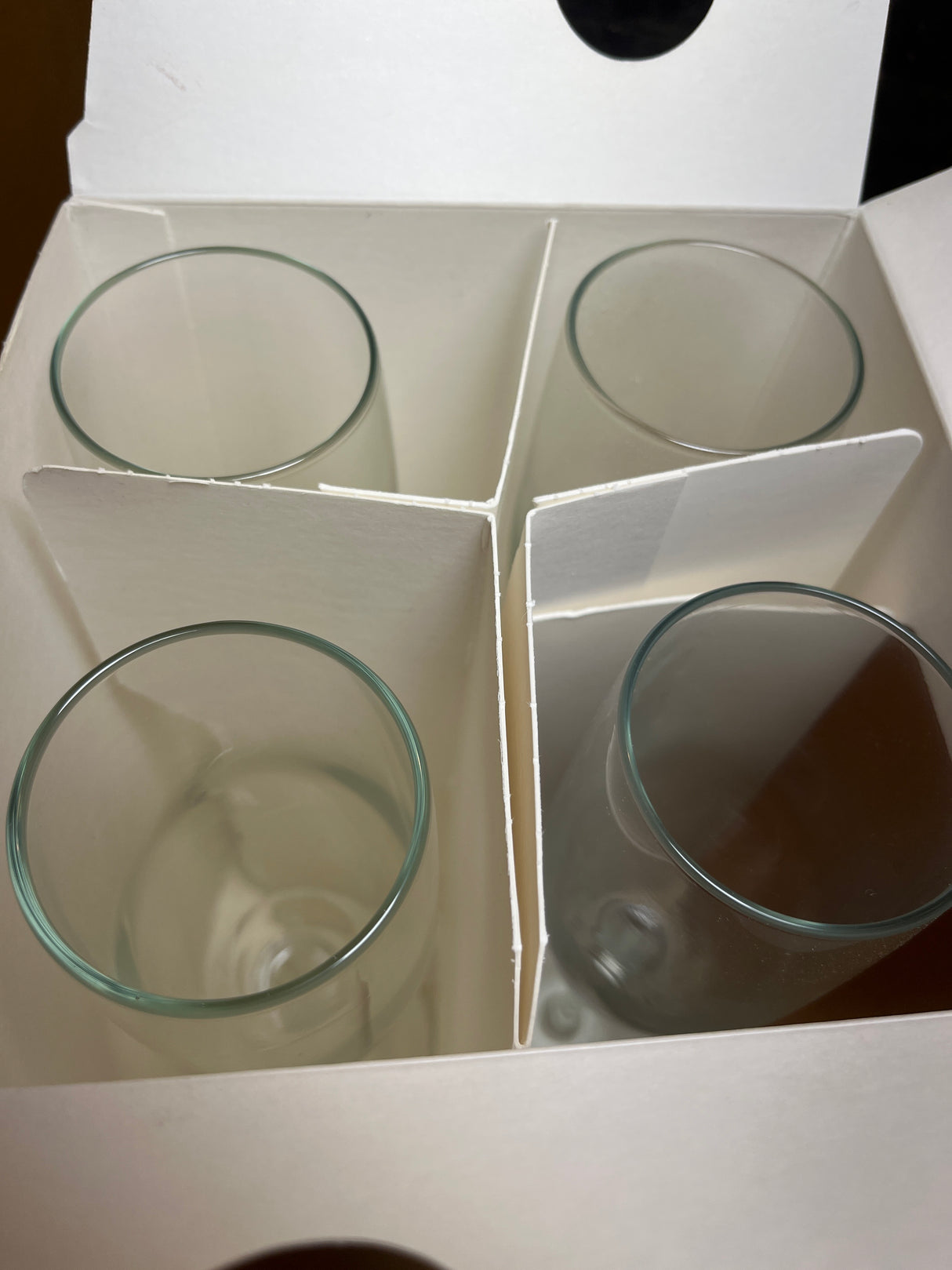 Libbey set of 4 champagne clary glasses in a cardboard box with individual compartments, showcasing clear, cylindrical glass tumblers neatly arranged.