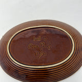 Underside of Hull Oven-Proof Brown Oval Plate with text that says, "hull (c) Oven Proof U.S.A." From Spoons Kitchen Exchange.