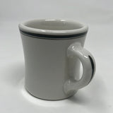 Victor coffee mug made of white ironware with a handle, featuring olive green accents on the rim, originally designed for U.S. military use.