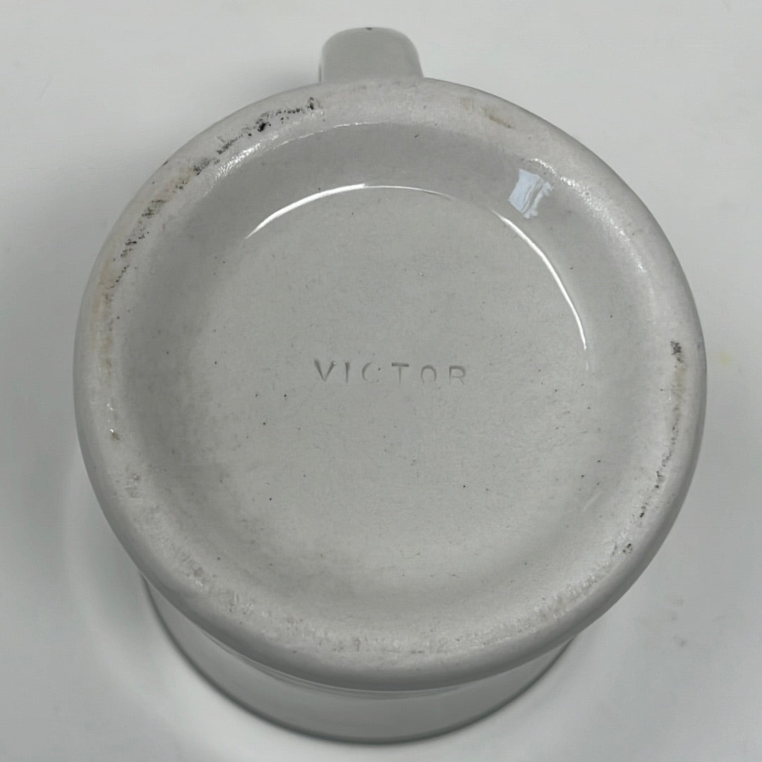 White Victor coffee mug made of heavy-duty ironware, featuring a name engraved, with olive green accents on the rim and handle.