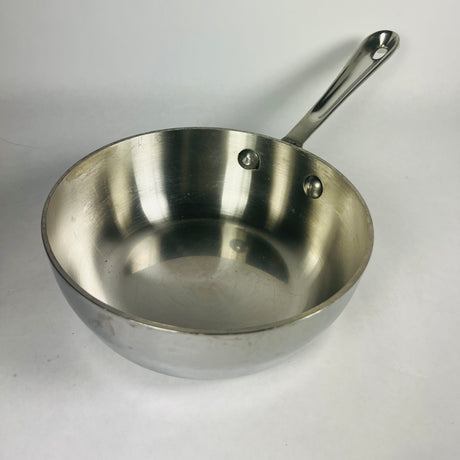 Small All-Clad stainless steel saucepan set against a white background. 