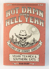 Cookbook cover with title “Hot Damn and Hell Yeah: Vegan Tex-Mex & Southern Eats,” featuring a desert scene and grinning skull in cowboy hat, by Ryan Splint.