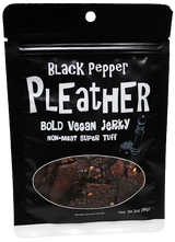 Pleather Vegan Jerky package with Black Pepper labeling, showing pepper-speckled strips through a clear window. Seitan-based, resealable 2 oz pack for on-the-go snacking.