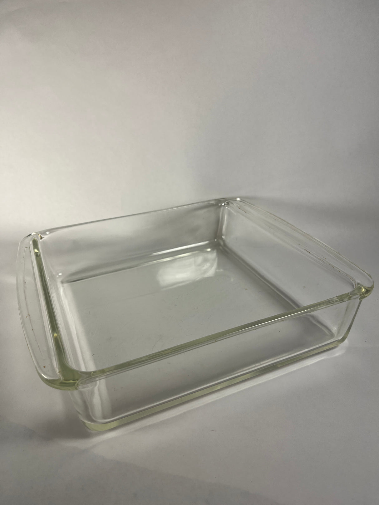 Pyrex baking dish with handle, clear glass, suitable for various sizes, ideal for kitchen use.