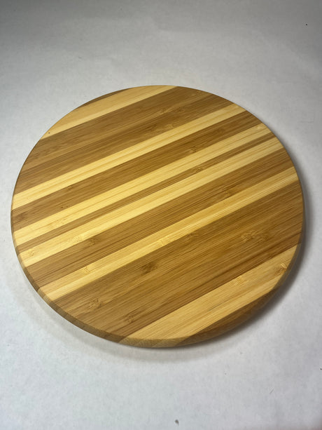 Circular wooden trivet on a white surface. From Spoons Kitchen Exchange. 