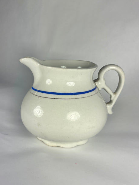 Carrollton China creamer with intricate handle and elegant trim.