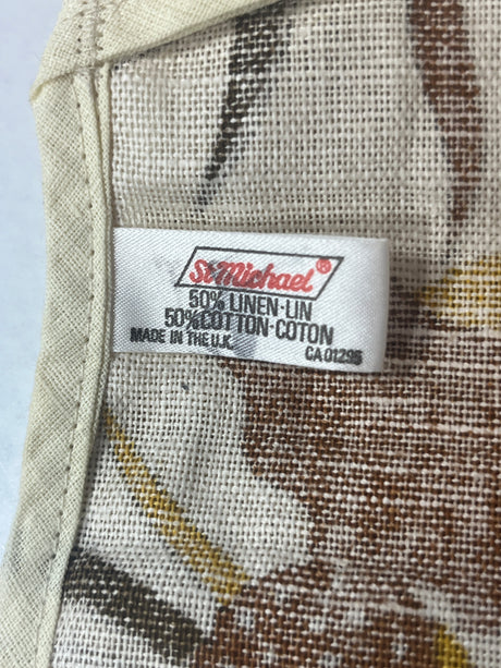 Closeup of label for a pair of retro oven mitts that reads, "St. Michael 50% linen, 50% cotton, made in the U.K.""