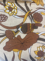 Closeup of a retro oven mitt set. The retro patten is shades of brown and yellow featuring a songbird amongst flowers.